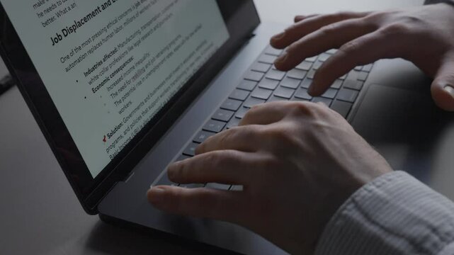 Man fertigt Bericht im B&uuml;ro an Schreibtisch mit Laptop an, sitzt im Schatten mit Gegenlicht der Fenster