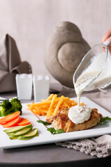Grilled Chicken Breast with Mushroom Sauce with fries and sliced vegetables served in plate isolated on table side view of gourmet meal presentation