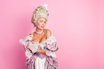 Elegant woman in vintage costume poses against pink background