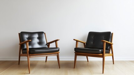 Two mid-century modern black leather armchairs facing each other in a minimalist room.