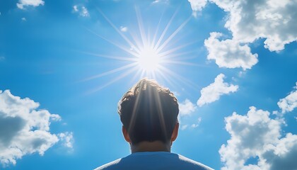 Rear View of a Man Gazing at the Sun in a Clear Blue Sky