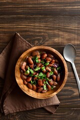 Baked beans in bowl on wooden table