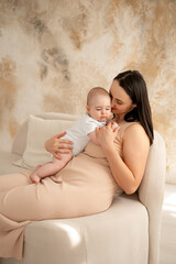 a mother holds a newborn baby in her arms, a mother gently hugs and kisses a small child, maternal love and care, a mom and a baby