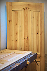 Natural wood doors made by a carpenter. Selective focus, vertical photo. Eco-friendly doors