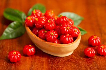 red fruits in a bowl on a wooden table