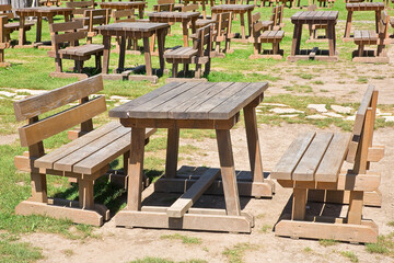 EMPTY WOODEN PICNIC TABLE WITH BENCHES on a green meadow in a public park - No people in the scene