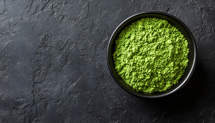 Wasabi powder in a bowl on a black textured table, top view. Space for text