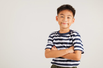 Fototapeta premium Asian happy portrait cute young kid boy smiling confidence with arms crossed studio shot isolated on white background and copy space, primary children person lifestyle arm folded
