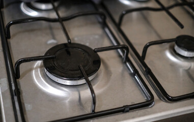 A stove with four burners and a black knob.