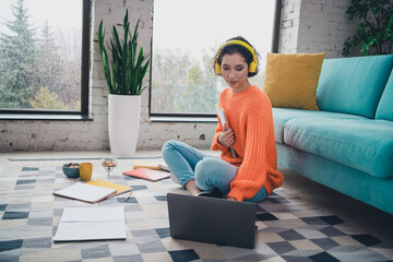 Young Woman Studying Comfortably at Home Wearing Headphones and Casual Pullover