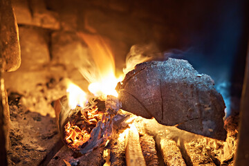 Lighting wood in a rural stove. Traditional stove in the countryside. Close-up of the hearth. Photo...