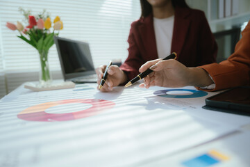 Businesswoman analyzing charts and financial data on laptop in modern office. She focuses on investment strategies and budget planning, collaborating with colleagues to drive organizational growth and