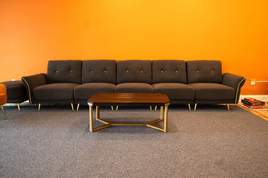 Modern Living Room with Stylish Dark Sofa and Bold Orange Accent Wall &ndash; Contemporary Interior Design Photography