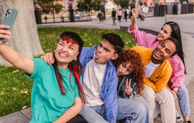 Group of young friends taking a selfie and making funny faces in a park