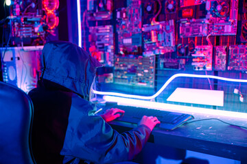 Woman hacker. Asian woman wearing hood is typing keyboard for coding hacking programming system....
