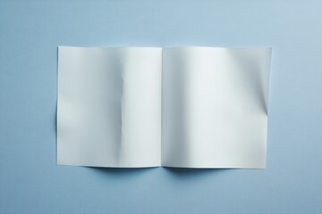 A blank open book on a soft light blue surface