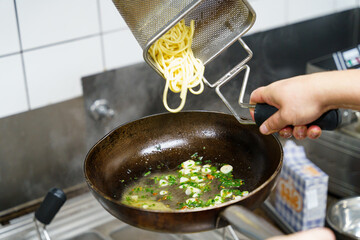 Adding Pasta to Herb Sauce in Pan
