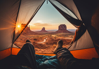 Inside view of tent facing stunning desert rock formations at sunrise, sleeping bag visible in foreground.
