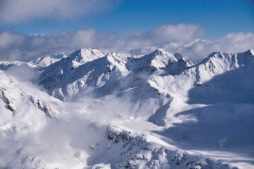 A stunning snowcovered mountain range shines under a clear blue sky, creating a vibrant atmosphere....