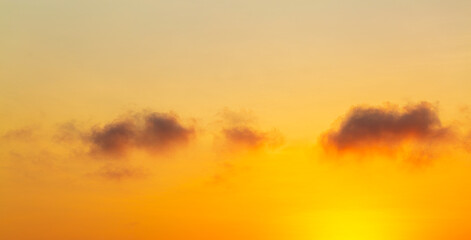 Fototapeta premium Clouds and orange sky,Beautiful Vivid sky painted by the sun leaving bright golden shades,Yellow sunlight in Golden hour or morning sunrise, Horizon sky nature background