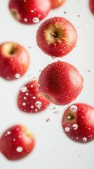 Bright red apples with water droplets falling on a white background. Juicy, fresh composition symbolizing health, vitamins, and nature.