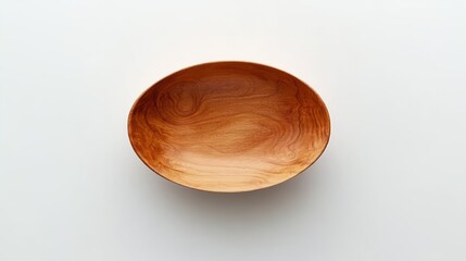 An oval wooden bowl sits isolated on a bright white surface