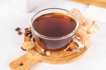 Fresh brewed ginger coffee cup. Dark coffee espresso hot drink with ginger powder and ginger root, on white background. Healthy hot drink. alternative medicine, remedy 