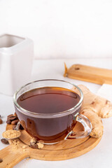 Fresh brewed ginger coffee cup. Dark coffee espresso hot drink with ginger powder and ginger root, on white background. Healthy hot drink. alternative medicine, remedy 