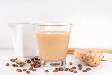 Fresh brewed ginger coffee latte cup. Creamy hot drink with ginger powder and ginger root, on white background. Healthy hot beverage. alternative medicine, remedy 