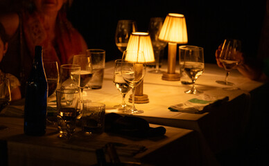 Warm ambiance at a cozy dining table with soft lighting and elegant glassware during an intimate...