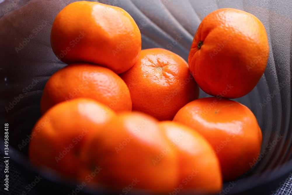 Poster a close-up view of a bowl filled with oranges on a table.