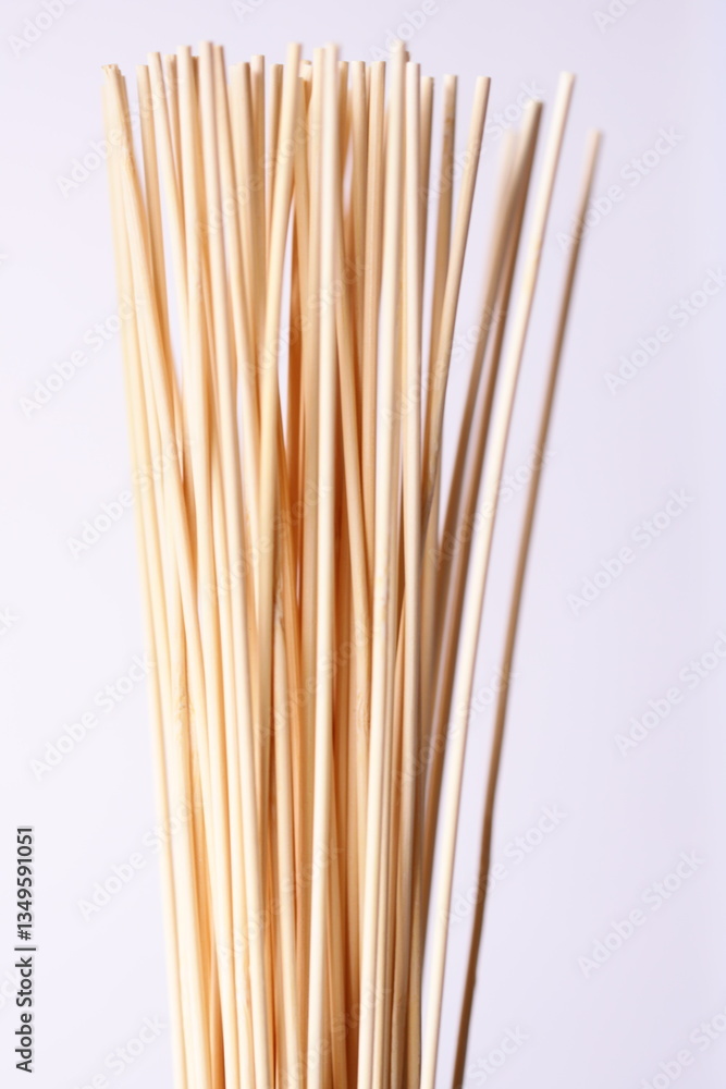 Poster A collection of bamboo sticks arranged neatly on a white background, suitable for use in design or photography projects.