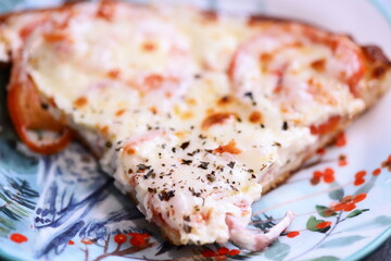 A single slice of pizza on a plate with a fork, ready for eating.