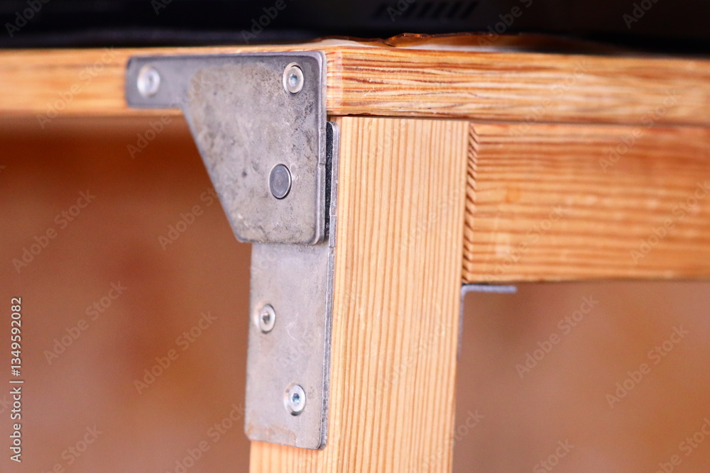 Poster A close-up shot of a wooden table with metal brackets, perfect for use in design or architecture projects.
