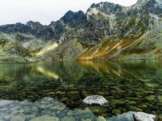 lake in the Serene alpine lake on the way to Koprovský Štít, Tatry Słowackie, with rugged peaks and clear water under a cloudy sky