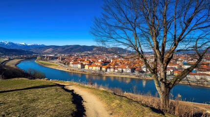 River-city panorama, winter trail, mountain backdrop, sunny day, travel