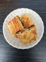 A blueberry cheese bar on a white saucer. Popular cookies for celebration of Eid Mubarak (Hari Raya). Malaysian famous dessert for Hari Raya