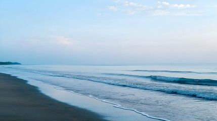 Blue Ocean Waves Rolling Onto Sandy Beach Under Clear Sky During Peaceful Afternoon