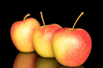 Three juicy apples, macro, isolated on black background.