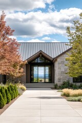 Modern architectural design of a countryside building with a welcoming entryway surrounded by colorful landscaping and clear blue skies