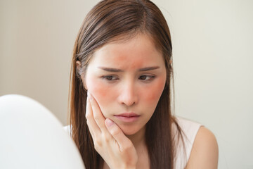 Dermatology, puberty asian young woman, girl looking into mirror, allergy presenting an allergic...