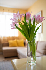 vase of pink dallas tulips in bright yellow living room