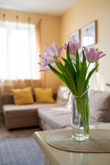 vase of pink dallas tulips in bright yellow living room