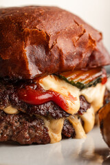 Close-Up of a Juicy Gourmet Cheeseburger with Melting Cheese and Sauce

