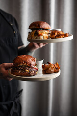 Chef Serving Gourmet Burgers with Roasted Potatoes in a Restaurant

