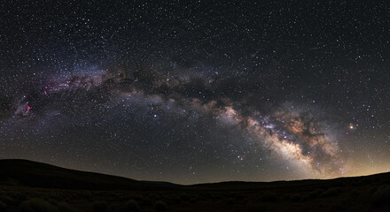 Fototapeta premium Majestic Milky Way Galaxy Arcing Over Dark Desert Landscape at Night