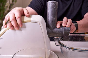 a man chops meat and vegetables in an electric meat grinder to make mincemeat for cutlets
