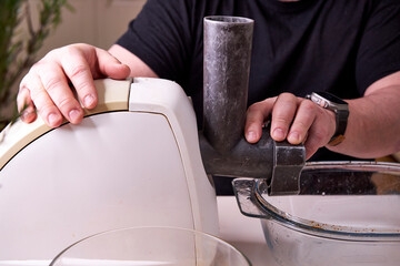 a man chops meat and vegetables in an electric meat grinder to make mincemeat for cutlets