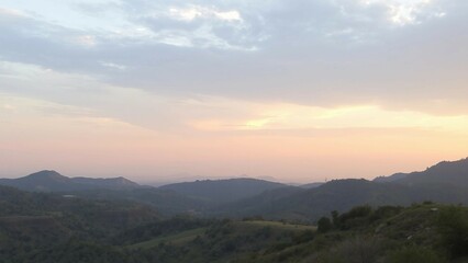 Sanfte Berglandschaft bei Sonnenuntergang mit pastellfarbenem Himmel, ideal für ruhige Natur- und Reisebilder.