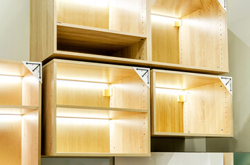 Contemporary wooden shelving units with integrated lighting. Empty shelves are in a modular...